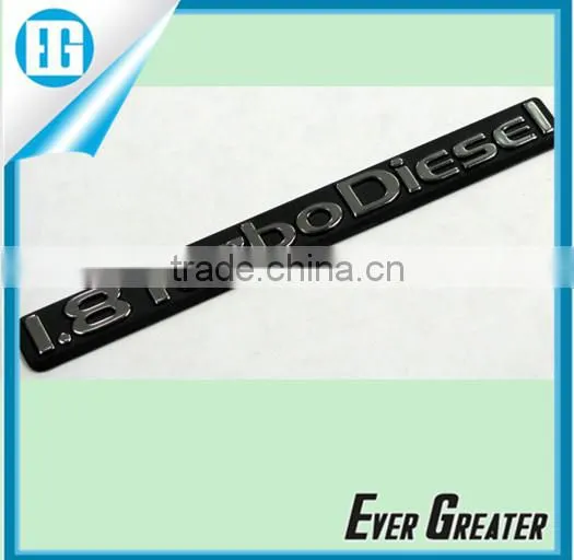 Resin coated domed label, embossed details, chrome Mylar printed black, self adhesive