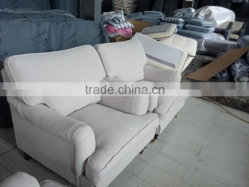beige linen sofa with metal rolling castor