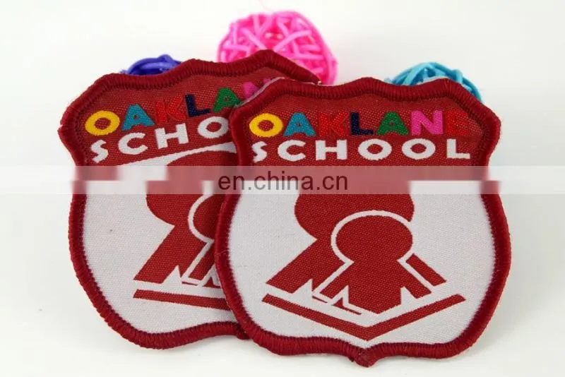 die cut shape with logo book and bird woven military emblems