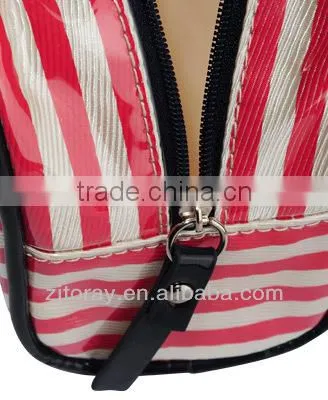 Small clear coated cosmetic bag featuring a coated stripe pattern zippered placket along the top