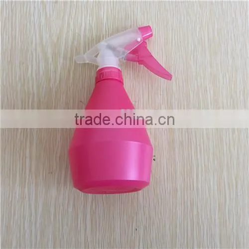 pink plastic garden spray bottle with trigger