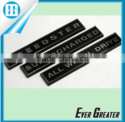 Resin coated domed label, embossed details, chrome Mylar printed black, self adhesive