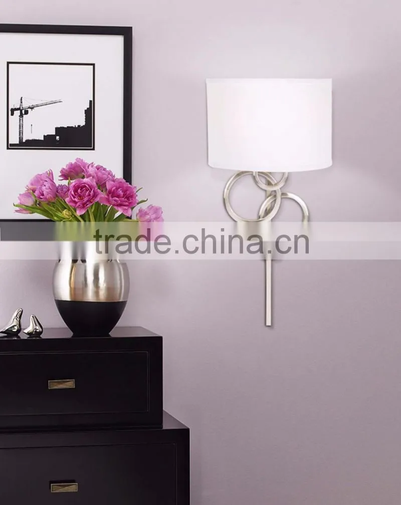 1017-1 sleek brushed steel finish raindrops falling on a calm body of water intertwining Circles Plug-In Wall Sconce