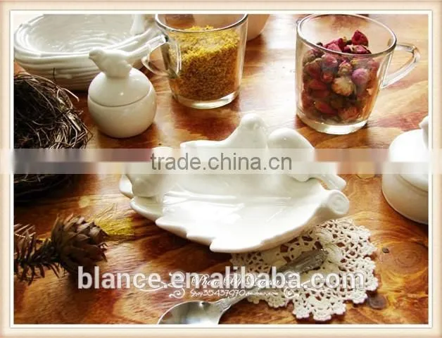 antique white porcelain plate with small bird in middle