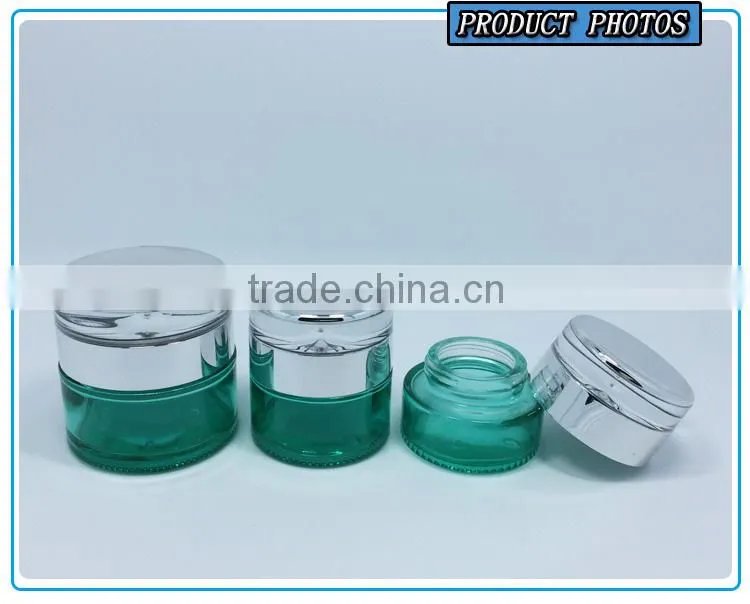 Empty green colored glass cosmetic bottle and cosmetic glass cream jar