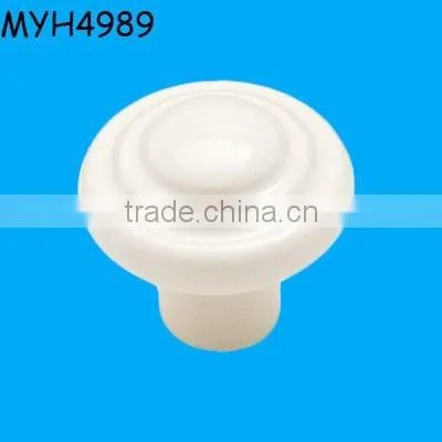 Plain white ceramic door knob with gold trim