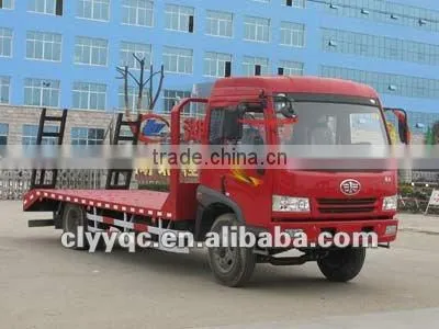 Flat bed construction machine towing flat bed transport truck