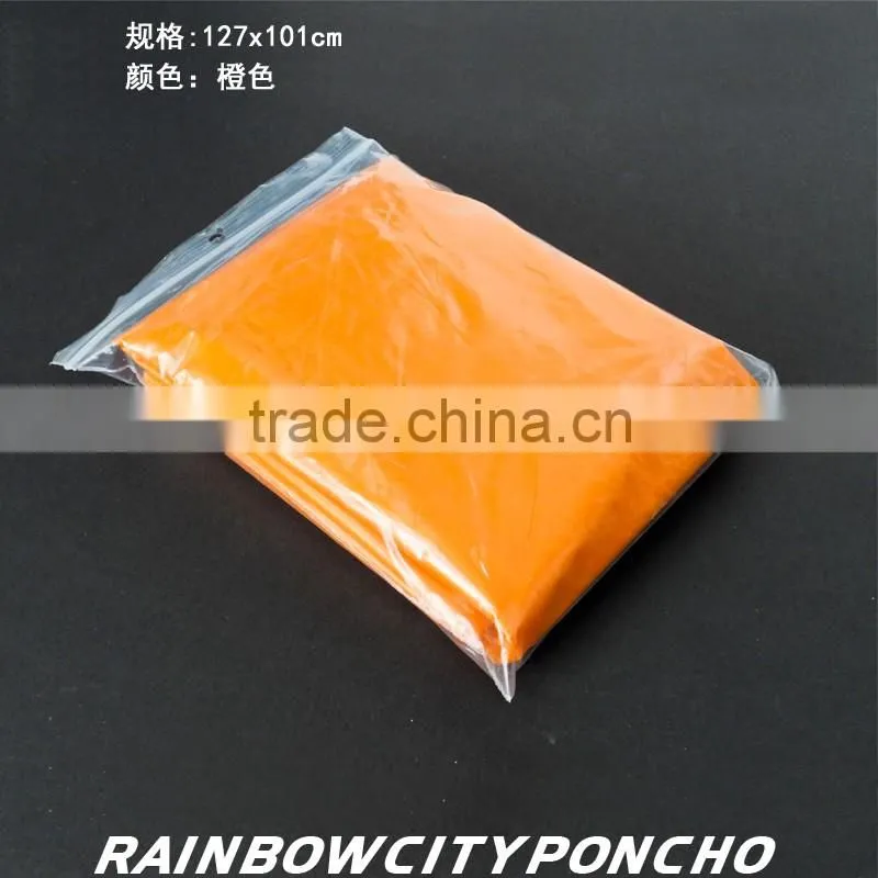 PE rainponcho orange color within paper card in the packing zipper bag
