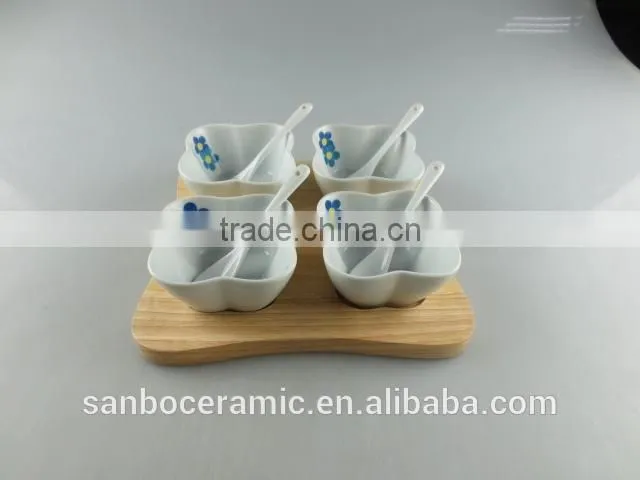 white porcelain clover-shaped dish set with spoon and wood tray