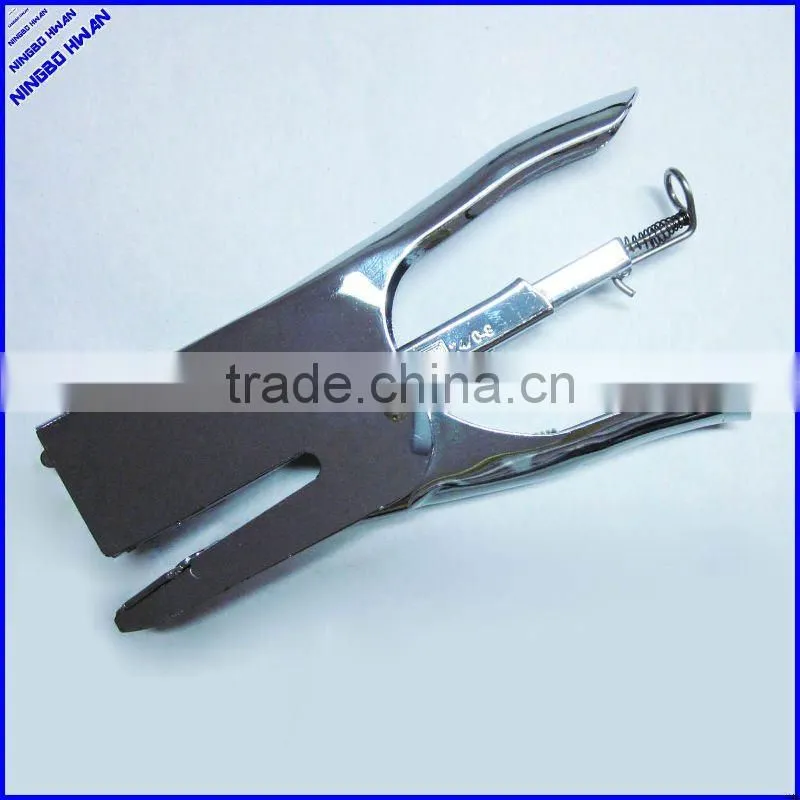 Las manos de alicate metal engrapadora