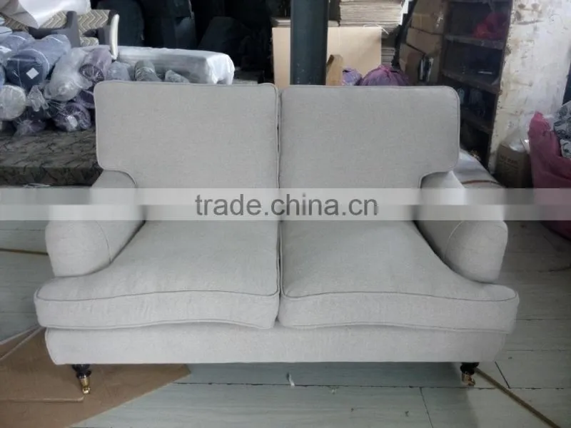 beige linen sofa with metal rolling castor