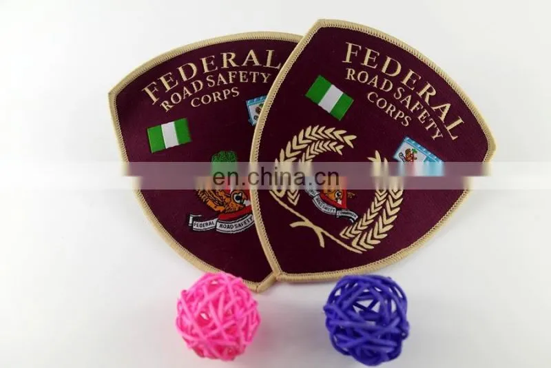 die cut shape with logo book and bird woven military emblems