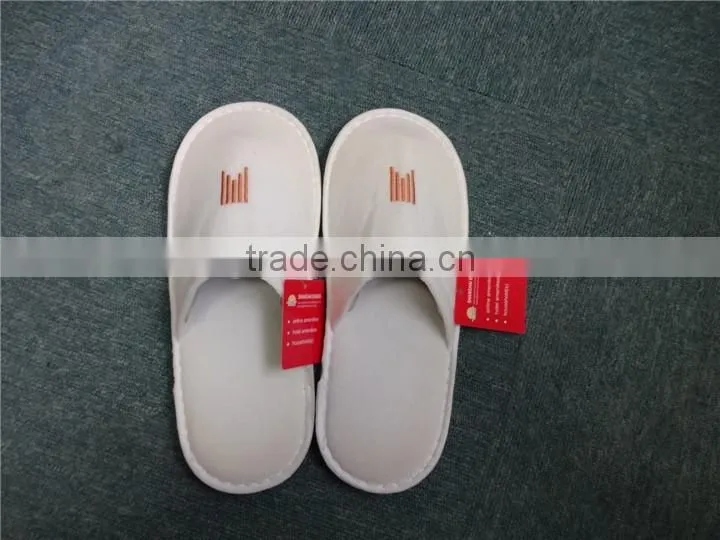 Brand new white fluffy indoor hotel bathroom slippers