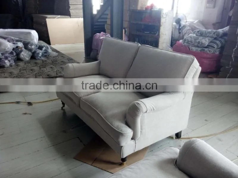 beige linen sofa with metal rolling castor