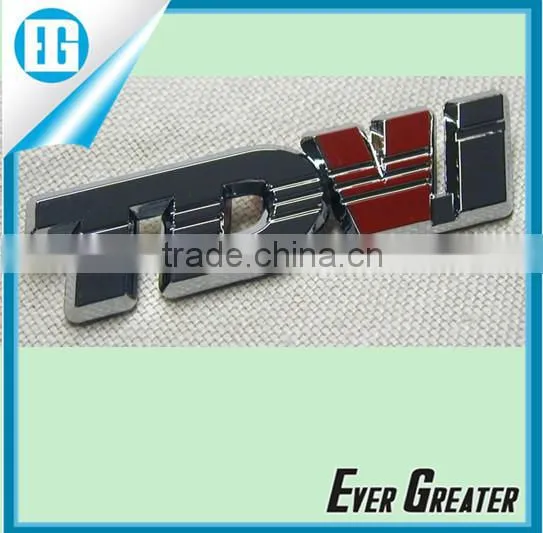 Resin coated domed label, embossed details, chrome Mylar printed black, self adhesive